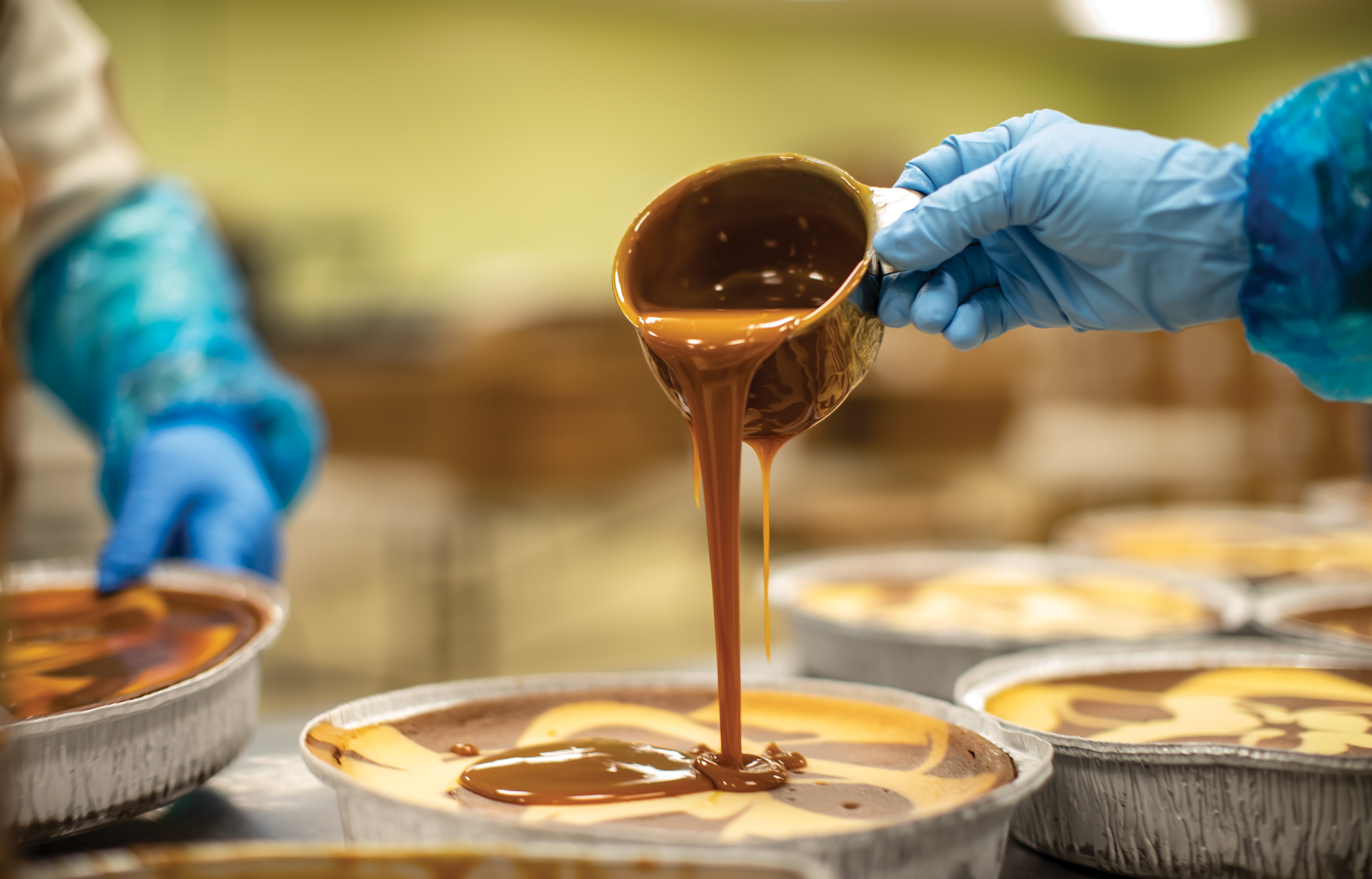 Image of worker pouring caramel over pie