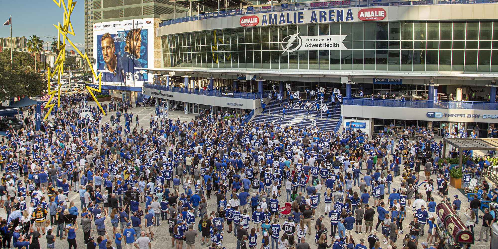 Lightning fans stand outside the Amalie Arena in their gear.