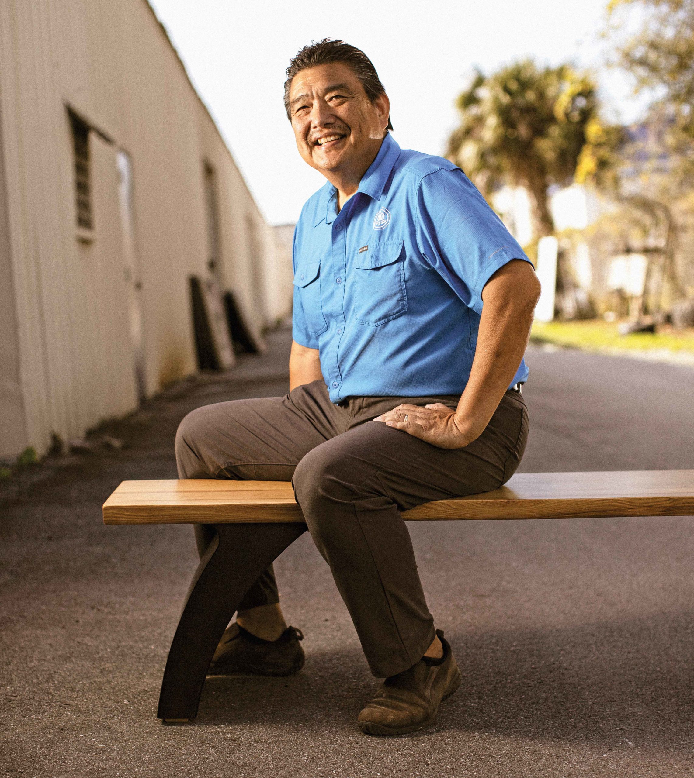 Ron Sato sits on a cypress bench made for E-Sushi, a Japanese restaurant in Odessa.