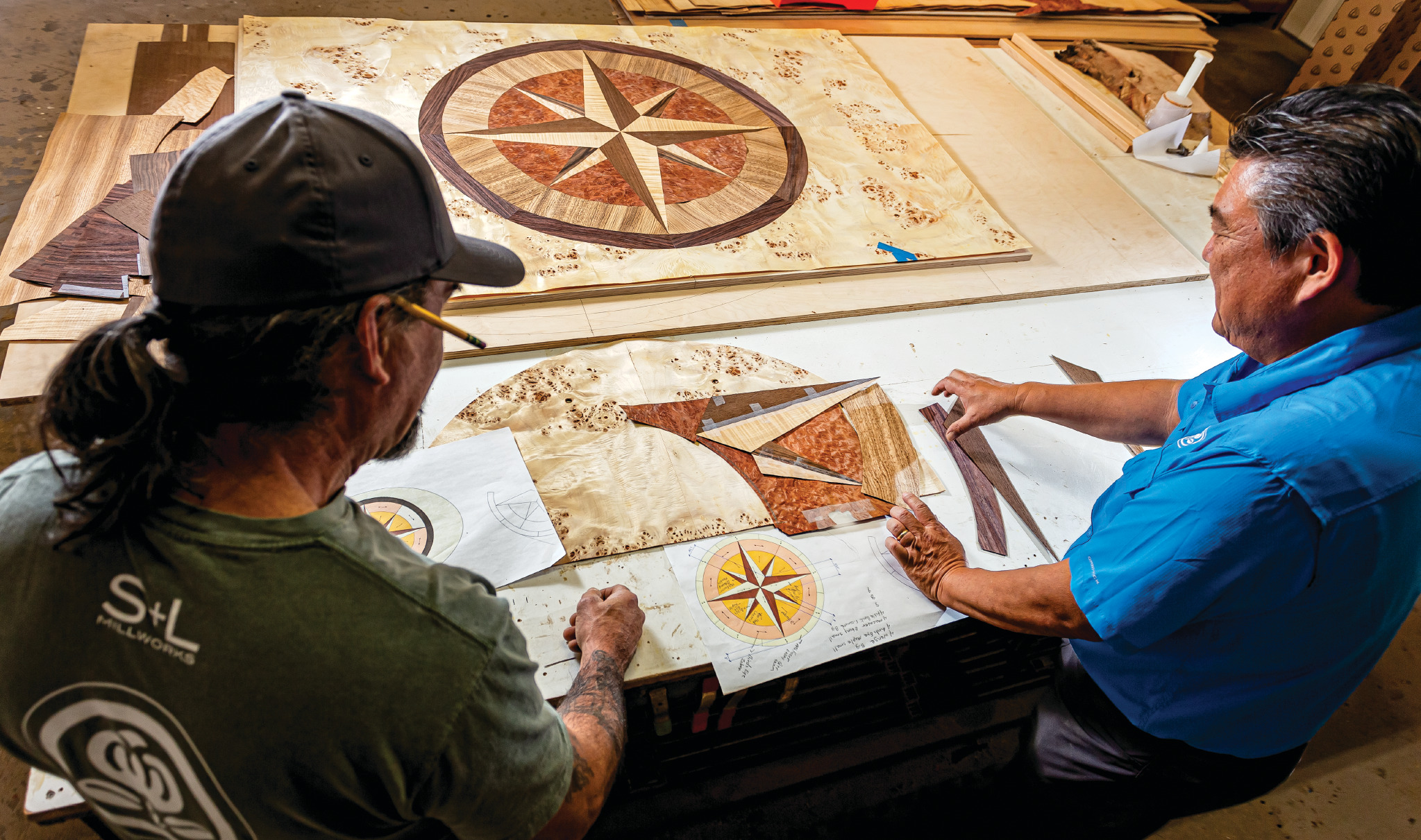 Diego Duran, left, and Ron Sato make a compass rose medallion with a variety of exotic veneers for a condo’s entryway ceiling.