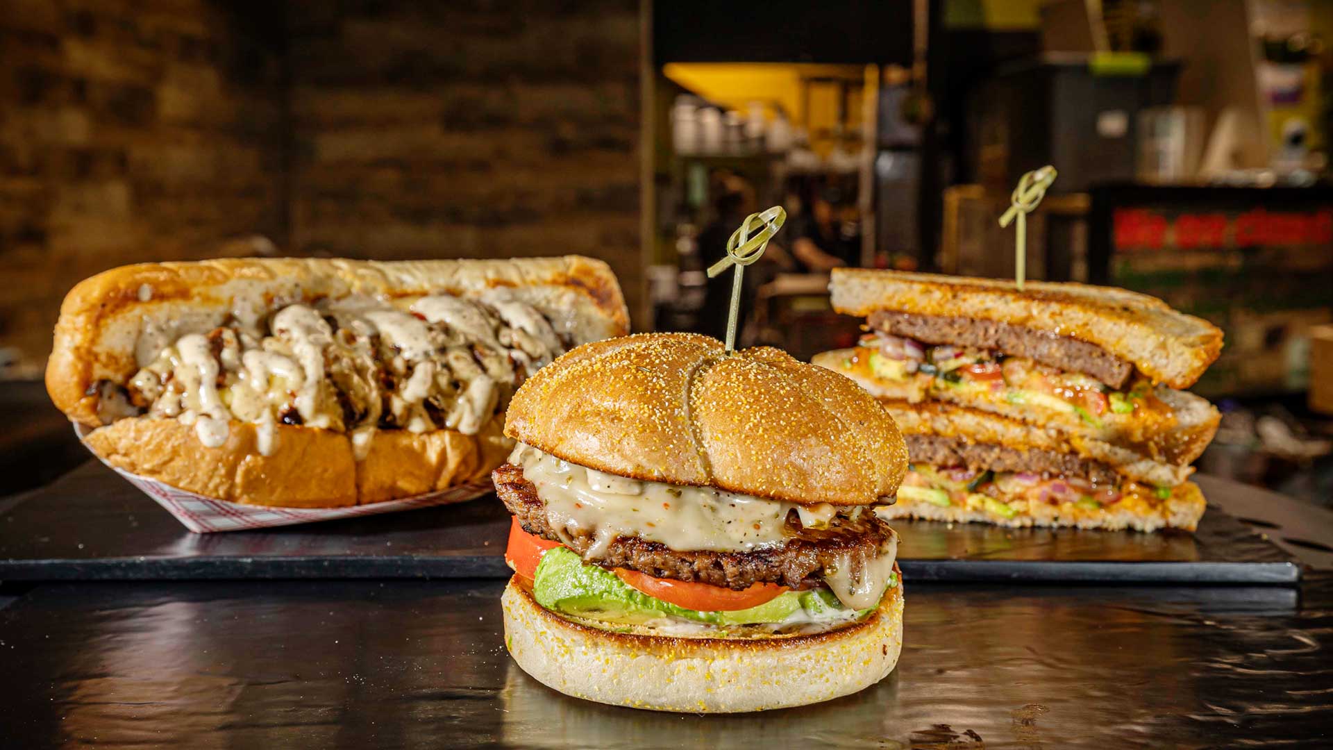 Farmacy is well known for their sandwiches. Pictured here (left to right) is their philly cheese steak, Farmacy burger, and frisco melt. (Photography by Gabriel Burgos)